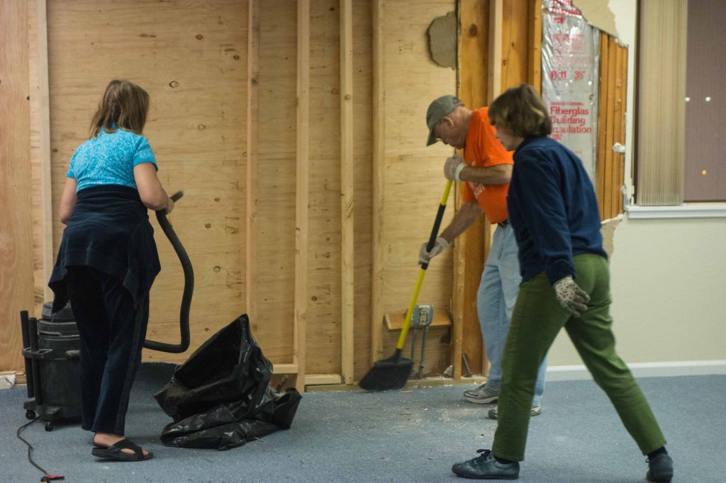 Jody, Lorin and Sharry vacuum near the front door.