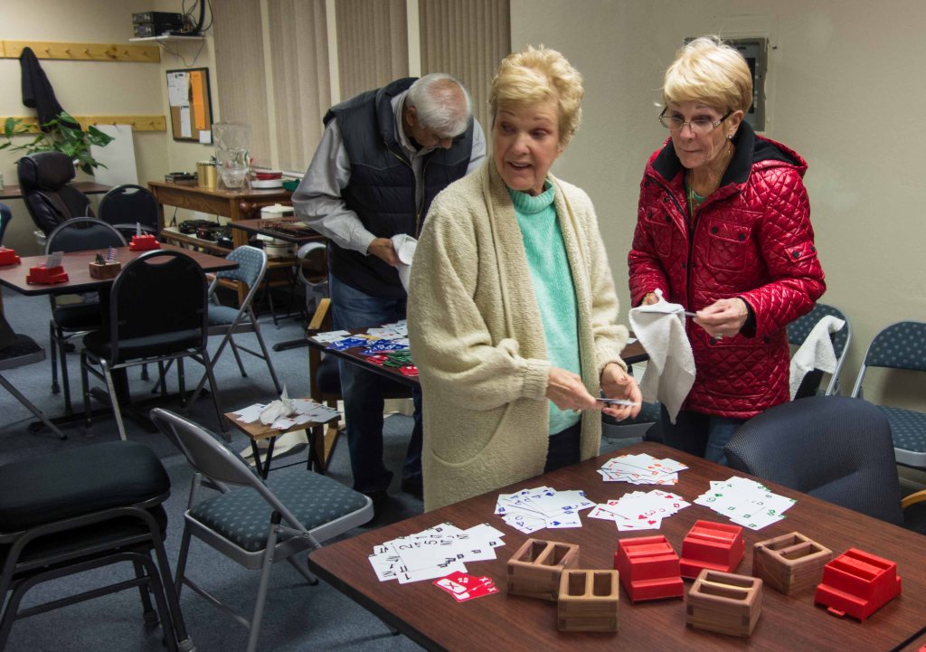 Bonnie Johnson and Kathy Grey putting bidding boxes back together