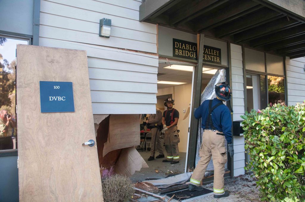 Firemen clearing out the damage to the front door so they could remove the car.