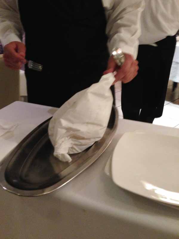 The specialty of the house, spaghetti and clams in parchment served tableside