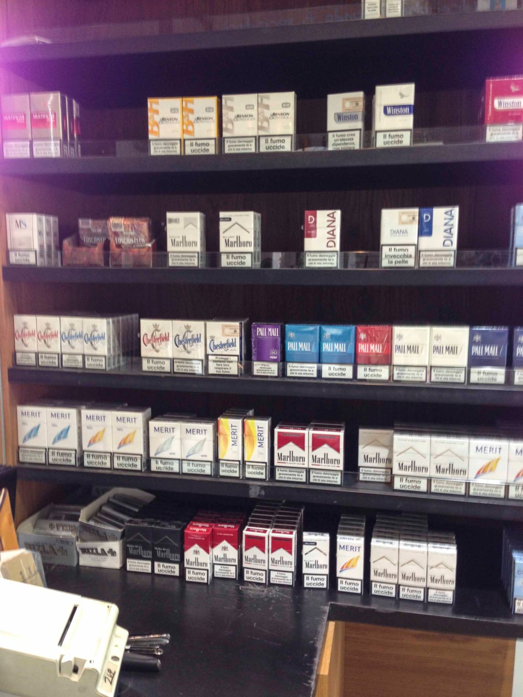 A rack of cigarettes behind the counter at a diner.