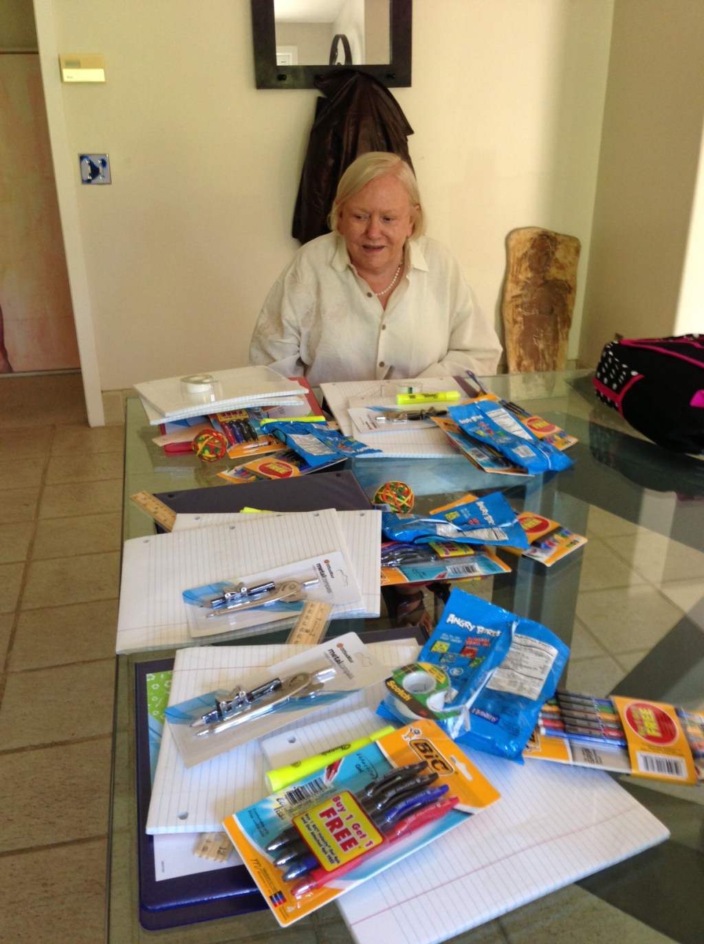 Busily assembling backpacks full of school supplies.