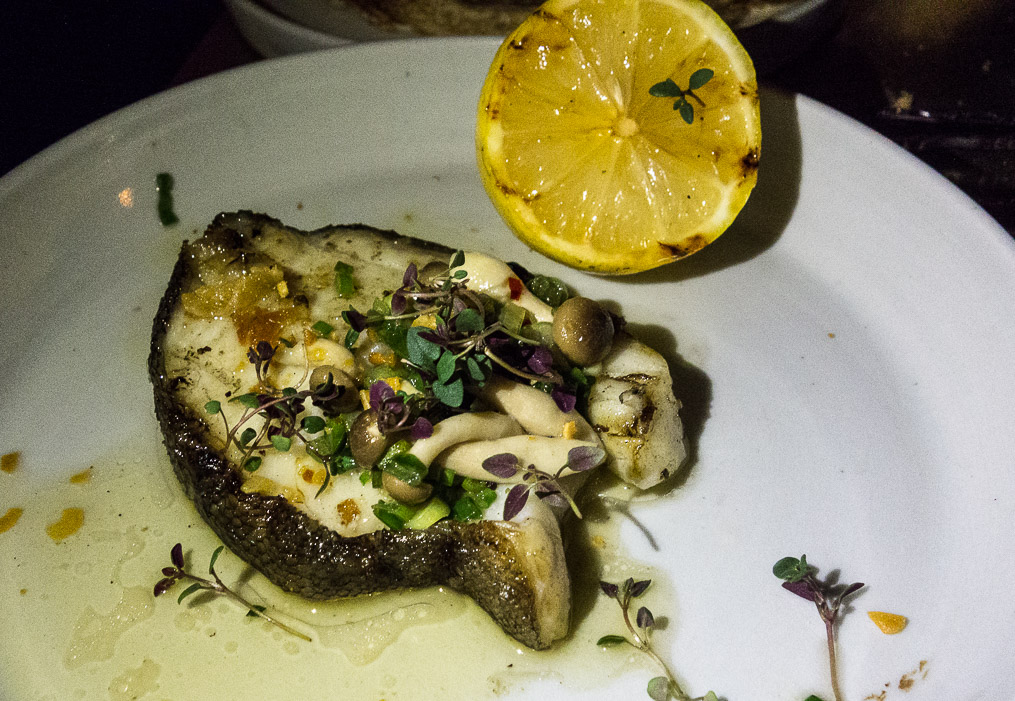 Black cod on a bare plate.