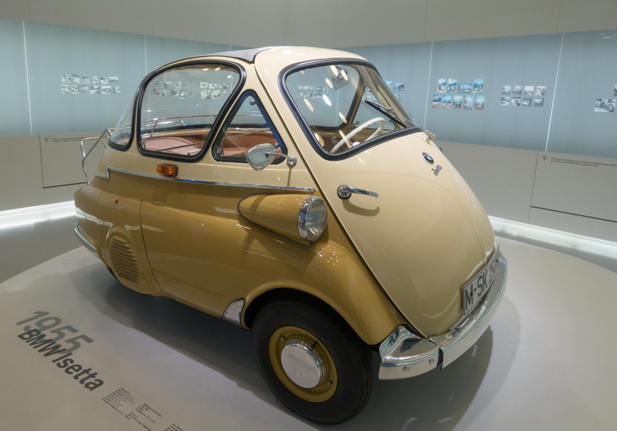 1955 Isetta.  There is only one door--the front of the vehicle opens out, steering wheel and all.