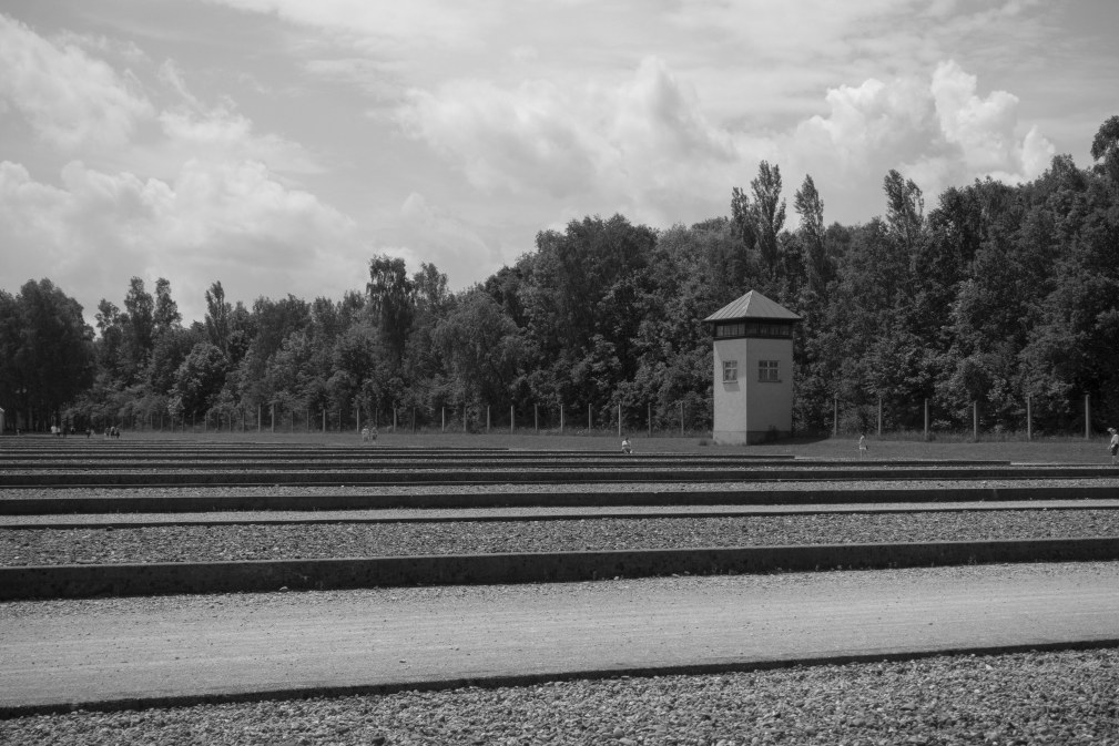 Foundations show where rows and rows of barracks stood, with a guard tower behind them.